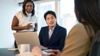 Des conseillers en affaire discutent avec une entrepreneure dans une salle de rencontres
