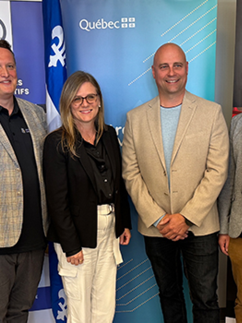 Groupe de personnes debout devant des bannières portant les logos « P2K Athlète », « Québec » et « Plate 2000 », dans un environnement intérieur lors d’un événement officiel.